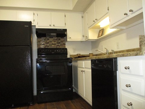 a kitchen with black appliances and white cabinets